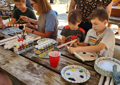 painting PVC pipe flutes for kids at cultural encampment