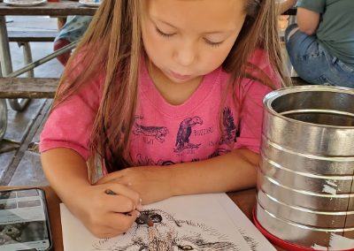 girl coloring a paper coyote mask